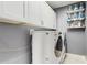 Well-organized laundry room with front load washer and dryer, storage cabinets, and shelving at 4002 Scarlet Branch Rd, Orlando, FL 32824