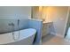 Serene bathroom featuring a modern soaking tub and a gray vanity with dual sinks at 4111 Sw 166Th Place Rd, Ocala, FL 34473
