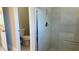 Modern bathroom with a walk-in shower featuring glass doors and a toilet at 4111 Sw 166Th Place Rd, Ocala, FL 34473
