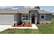 Charming single-story home featuring a landscaped yard, modern paint, and an attached garage at 4111 Sw 166Th Place Rd, Ocala, FL 34473