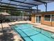 Screened-in pool area with brick pavers, lounge chairs, and dining set at 4251 Anthony Lane, Orlando, FL 32822