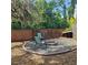 Backyard fire pit area with chairs, brick border, and wooded backdrop, perfect for outdoor relaxation and entertainment at 513 Rachael Ct, Oviedo, FL 32765