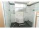 Elegant bathroom boasts tiled walk-in shower, upgraded fixtures, and stylish black hexagon floor tiles at 513 Rachael Ct, Oviedo, FL 32765
