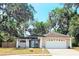 Inviting home featuring a neutral paint scheme and lush landscaping with beautiful, mature trees at 513 Rachael Ct, Oviedo, FL 32765