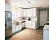 Well-lit kitchen features white cabinets, stainless steel appliances, updated countertops, and hardwood flooring at 513 Rachael Ct, Oviedo, FL 32765
