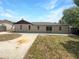 View of the backyard featuring a concrete area, grassy areas, and the back exterior of the house at 52 Hydrangea Ln, Debary, FL 32713