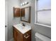 Bathroom with a single sink vanity with wood cabinets, tiled flooring, and updated lighting at 52 Hydrangea Ln, Debary, FL 32713