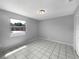 Clean bedroom with tile floors, a window bringing in sunlight, and a minimalist aesthetic at 52 Hydrangea Ln, Debary, FL 32713