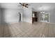 A spacious living room with tile flooring, a ceiling fan, and sliding glass doors to the backyard at 52 Hydrangea Ln, Debary, FL 32713