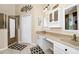 Bright bathroom featuring double sinks, white cabinetry, and a glass-enclosed shower at 5431 White Heron Pl, Oviedo, FL 32765
