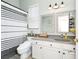 Bathroom with a double sink, gray granite countertops, white cabinets, and a shower with a gray and white striped curtain at 5431 White Heron Pl, Oviedo, FL 32765