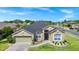 Well-manicured home features a two-car garage, lush green lawn, and mature trees under a bright blue sky at 5431 White Heron Pl, Oviedo, FL 32765