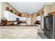 Spacious kitchen with a breakfast bar, granite countertops, and stainless steel refrigerator at 5431 White Heron Pl, Oviedo, FL 32765