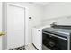Modern laundry room featuring a side-by-side washer and dryer, with shelving at 5431 White Heron Pl, Oviedo, FL 32765