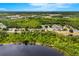 A captivating aerial view showcases a neighborhood surrounded by lush greenery and a serene lake at 555 Carey Way, Orlando, FL 32825