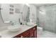 Modern bathroom with double bowl sinks, cherry cabinets, quartz countertop, and a walk-in glass shower at 555 Carey Way, Orlando, FL 32825