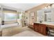 Spacious bathroom featuring a bathtub and glass-enclosed shower with vanity at 555 Carey Way, Orlando, FL 32825