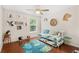 Bright bedroom featuring hardwood floors, ceiling fan, cheerful decor, daybed, and a large window at 555 Carey Way, Orlando, FL 32825