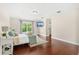 Bright bedroom featuring hardwood floors, tray ceiling and a large window with a view of the garden at 555 Carey Way, Orlando, FL 32825