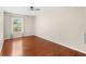 Spacious bedroom with hardwood floors, ceiling fan, and natural light from a window at 555 Carey Way, Orlando, FL 32825
