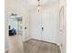 Bright entryway features double doors and a view into the home office with a computer and blue chair at 555 Carey Way, Orlando, FL 32825