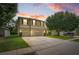Two-story home featuring a well-manicured lawn, mature landscaping, and a spacious three-car garage at 555 Carey Way, Orlando, FL 32825