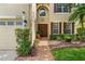 Charming home exterior featuring a brick pathway, lush landscaping, and a warm, inviting entrance at 555 Carey Way, Orlando, FL 32825