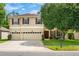 Charming two-story home with a three-car garage, lush landscaping, and a well-maintained front yard at 555 Carey Way, Orlando, FL 32825