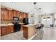 Well-equipped kitchen featuring wood cabinetry, modern appliances, a breakfast bar, and laminate flooring at 555 Carey Way, Orlando, FL 32825