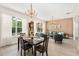 Open-concept living and dining area with hardwood floors, updated chandelier, and natural light at 555 Carey Way, Orlando, FL 32825