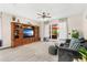 Bright living room featuring light-colored wood floors, a ceiling fan, and large entertainment center at 555 Carey Way, Orlando, FL 32825