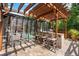Outdoor kitchen with a grill, bar seating, and a view of the screened-in pool and lush greenery at 555 Carey Way, Orlando, FL 32825