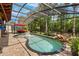 The screened-in pool has brick pavers, a waterfall feature, tropical foliage and comfortable seating at 555 Carey Way, Orlando, FL 32825