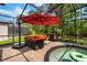 This covered pool patio features outdoor seating, a fireplace, and a hot tub at 555 Carey Way, Orlando, FL 32825