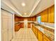 Traditional kitchen featuring wood cabinets with granite countertops and tile floors, ideal for cooking and entertaining at 6001 Beau Ln, Orlando, FL 32808