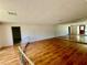 Bright living room showcasing hardwood floors, an accent wall mirror, and an open staircase at 6001 Beau Ln, Orlando, FL 32808