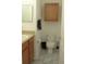 Small bathroom with wooden vanity, tiled floors, a standard toilet, and a wall mirror at 6117 Metrowest Blvd # 106, Orlando, FL 32835