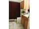 Bathroom featuring a maroon shower curtain, marble-like tile, and a wooden vanity with drawers at 6117 Metrowest Blvd # 106, Orlando, FL 32835
