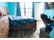 Bedroom with blue walls and wood floors featuring a bed, and a view out the window at 6117 Metrowest Blvd # 106, Orlando, FL 32835