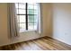 Charming bedroom with wood flooring and a large window adorned with gray curtains at 6117 Metrowest Blvd # 106, Orlando, FL 32835