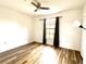 Bright bedroom featuring a ceiling fan, wood-look flooring and a window with black out curtains at 6117 Metrowest Blvd # 106, Orlando, FL 32835