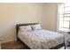 Bedroom featuring a bed with floral patterned bedding and wood-look flooring near a window at 6117 Metrowest Blvd # 106, Orlando, FL 32835