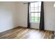 This bedroom has beautiful wood look floors and a window with black trim at 6117 Metrowest Blvd # 106, Orlando, FL 32835