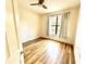 Cozy bedroom with wood-look floors, ceiling fan, and a large window at 6117 Metrowest Blvd # 106, Orlando, FL 32835