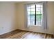 Cozy bedroom with wood floors, large window with curtains, and natural light at 6117 Metrowest Blvd # 106, Orlando, FL 32835