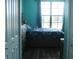 Bedroom with hardwood floors, blue walls, and an exterior view from the window at 6117 Metrowest Blvd # 106, Orlando, FL 32835