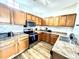 Well-lit kitchen with wood cabinets, stainless steel appliances, and tile backsplash at 6117 Metrowest Blvd # 106, Orlando, FL 32835