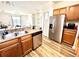 Kitchen with stainless steel appliances, wood cabinets, and open access to living area at 6117 Metrowest Blvd # 106, Orlando, FL 32835