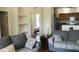 Bright living room with hardwood floors, built-in shelving, and a kitchen in the background at 6117 Metrowest Blvd # 106, Orlando, FL 32835