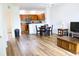 Open-concept living room with wood floors flowing into the kitchen, bright lighting, and minimalist decor at 6117 Metrowest Blvd # 106, Orlando, FL 32835